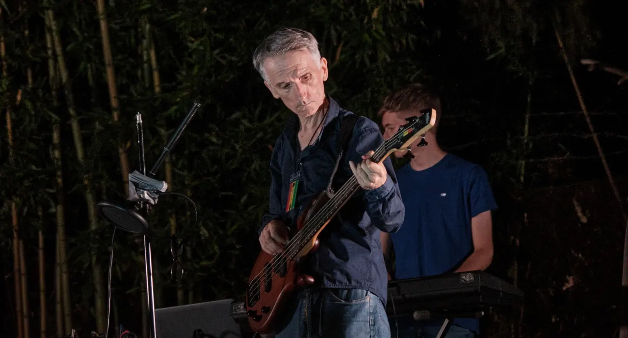 Antonio Lanni al basso durante un concerto serale tra i bambù